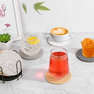 Set of woven cotton drink coasters in multiple colors with a sleek black metal holder