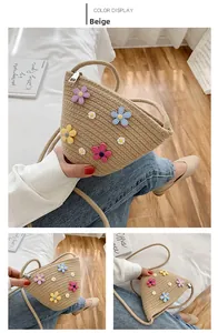 Détail du sac bandoulière en paille kaki avec appliques de fleurs et fermeture éclair argentée