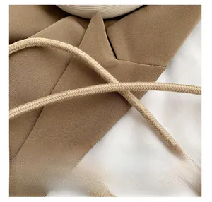 Detail of woven straw shoulder bag featuring textured fabric and thick braided handle