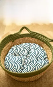 Detailed top view of woven cat bed with forest green trim and wave pattern cushion