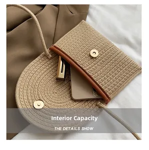 Detailed view of woven envelope bag interior holding a smartphone and lipstick