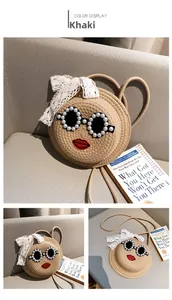 Detailed view of khaki woven straw bag featuring pearl sunglasses and red lip embroidery