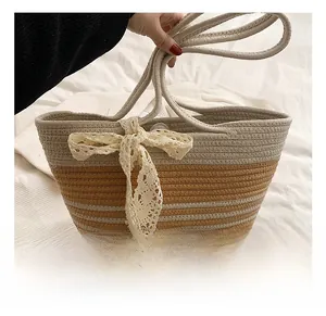 Detail of woven beach tote showing two-tone striped texture and lace bow ornament