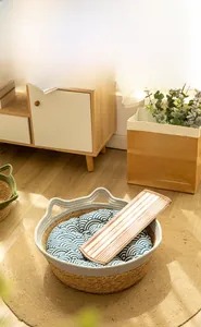 Detail of woven cat nest with cute ear handles, including cooling mat and wavy pattern cushion