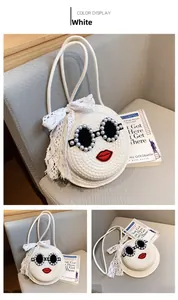 Detail view of woven straw crossbody bag featuring pearl sunglasses and red lip embroidery