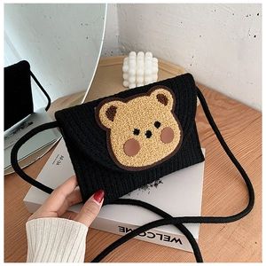 Detail of black woven crossbody phone bag with cute khaki teddy bear decoration