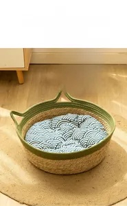 Detail of woven cat nest with green rim handles and blue wave pattern soft inner cushion