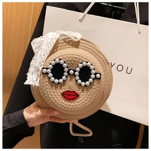 Detail of woven straw bag with pearl sunglasses design and lace bow accent