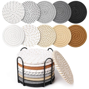 11-piece set of woven cotton coasters with round spiral textures and black metal storage holder