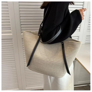 Chic woven cotton rope bucket bag with black leather shoulder strap for beach or daily use