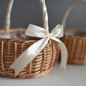 Handwoven natural wicker flower basket with elegant cream satin ribbon bow handle