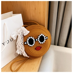 Close-up of woven straw bag featuring pearl sunglasses, red lips, and lace bow