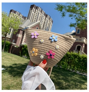 Vue détaillée du sac en paille tressée avec fleurs 3D colorées et fermeture éclair en métal