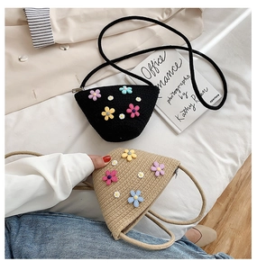 Détail de sacs bandoulière triangulaires en paille avec des fleurs colorées en beige et noir