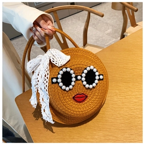 Detail of round straw bag featuring pearl sunglasses design and white lace bow decoration