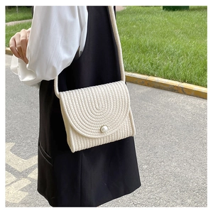 Dettaglio della borsa in cotone intrecciato bianco panna con bottone di perla e trama