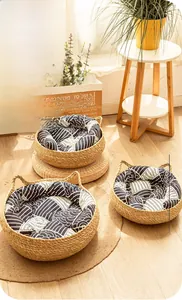 Detailed close-up of handmade wicker cat bed set with blue cushions on wooden floor