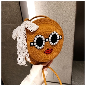 Detail of round straw crossbody bag with pearl sunglasses and lace bow decoration