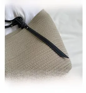 Detailed macro view of the woven cotton texture and black leather strap with white stitching