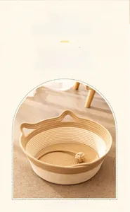 Detail showing handwoven two-tone pet bed with cat ear handles and small interior toy ball