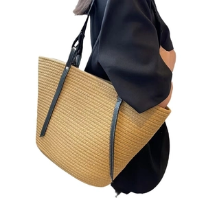 Handmade beige woven cotton bucket tote bag with long black leather handles for beach