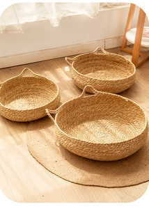 Three-piece set of woven seagrass storage baskets with handles in a warm home setting
