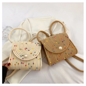 Dettaglio mini borse a busta intrecciate a mano con pois colorati e chiusura a perla