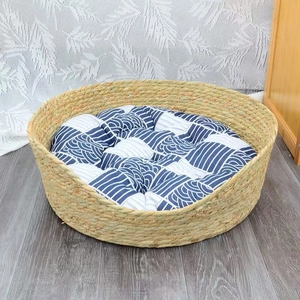 Detail view of a handcrafted wicker cat bed with a soft blue and white wavy cushion