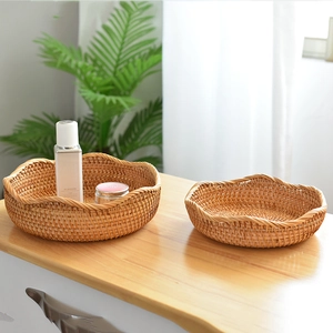 Close-up of wavy edge detail on handmade natural rattan fruit baskets in a set of two