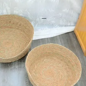 Detail of woven natural grass cat bed showing spiral texture and ergonomic low-front design