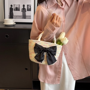 Borsa a secchiello in paglia intrecciata con motivi colorati e un grande fiocco nero