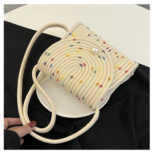 Dettaglio della borsa a busta tessuta a mano con fibbia di perle e pois colorati