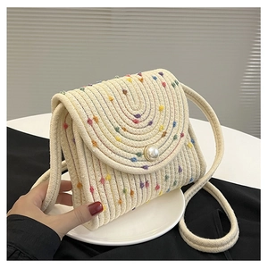 Dettaglio della borsa in corda di cotone intrecciata con pois colorati e chiusura a perla