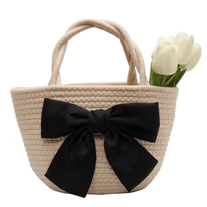 Borsa a secchiello in paglia intrecciata a mano beige con grande fiocco decorativo nero