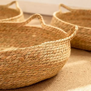 Handcrafted round rattan cat bed with handles made from natural woven straw material