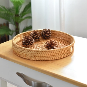 Close-up of handmade round rattan tray with hollow handles for home storage and decor