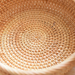 Detailed close-up of handmade rattan basket showing tight spiral weave texture and natural wood tone
