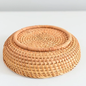 Close-up macro of handcrafted round rattan storage basket showing sturdy woven bottom texture