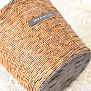 Detail of woven rattan basket texture featuring a leather label with decorative text