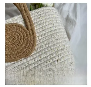 Detail of hand-woven tote bag showing beige cotton rope texture with gold silk accents