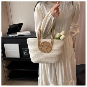 Detailed close-up of woven cotton tote bag featuring round handles and decorative tulip flower