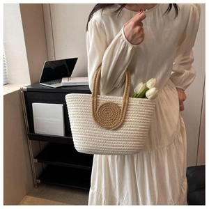 Close-up of woven tote bag with brown spiral detail and stylish brown top handles
