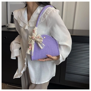 Detail view of purple woven shoulder bag with floral lace scarf handle and metal snap