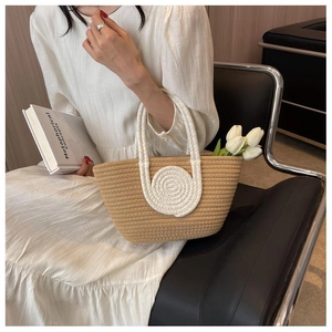 Detail of woven tote bag with white spiral pattern and tulip flowers in lifestyle setting
