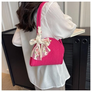 Detail of rose red woven shoulder bag with floral lace bow and gold metal buckle closure