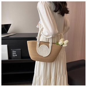 Detailed close-up of woven tote bag with white rope spirals and fresh tulips inside