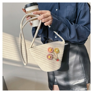 Détail de mini sac seau tissé avec fleurs au crochet et pendentif en forme de coccinelle