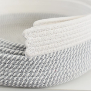 Détail macro du panier tissé pour chat en coton avec coutures renforcées blanc et gris