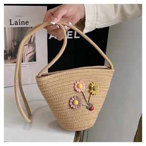 Détail du sac seau en paille tissé main avec fleurs crochetées 3D et coccinelle