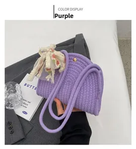 Detail of purple woven shoulder bag with floral silk ribbon bow and metal clasp